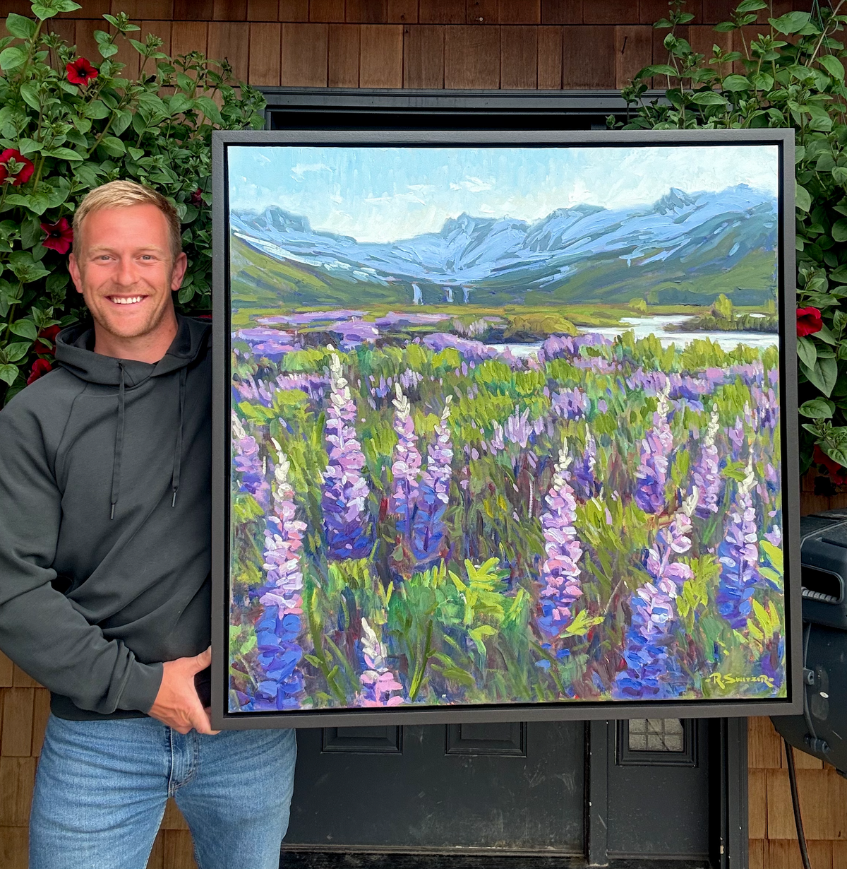 Robby Switzer with Valley Bloom, a 36 by 36 inch oil painting of lupine